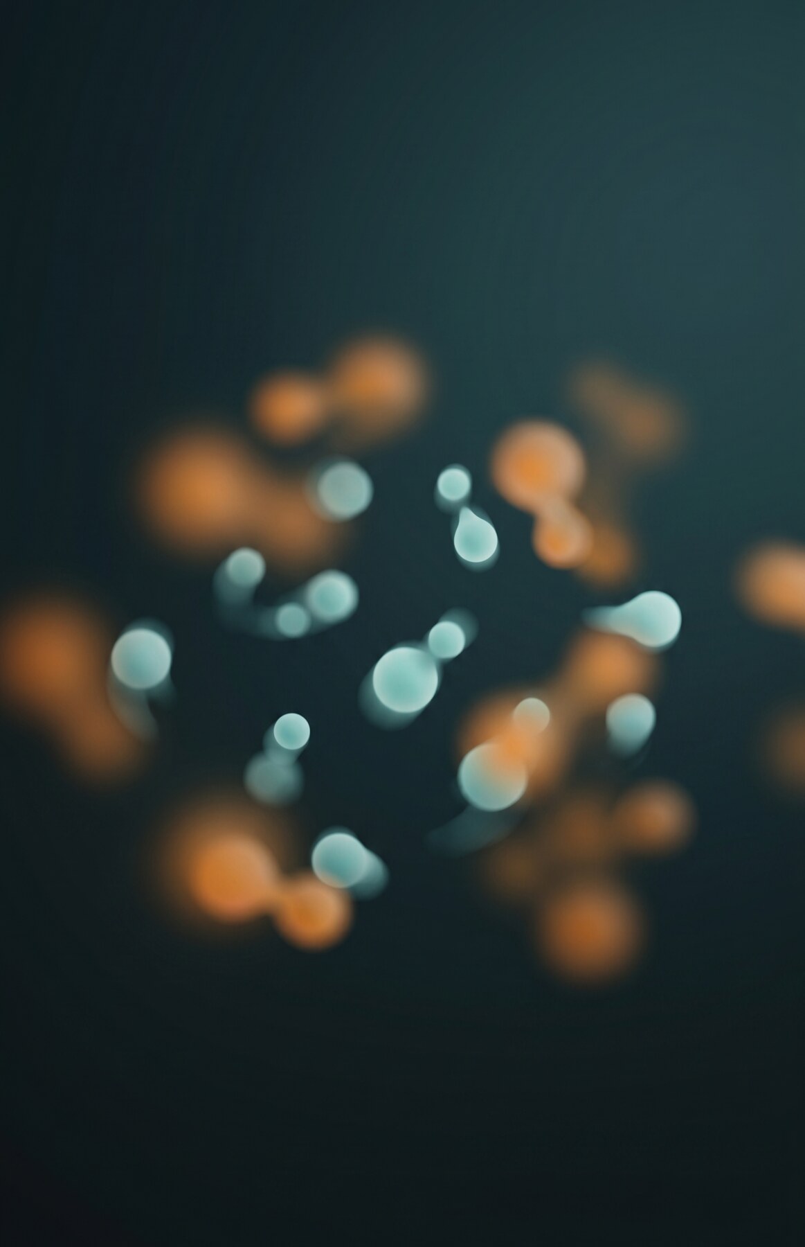 An abstract close-up of pale teal molecular forms drifting through softer warm amber shapes, suggesting the selective antioxidant mechanism.