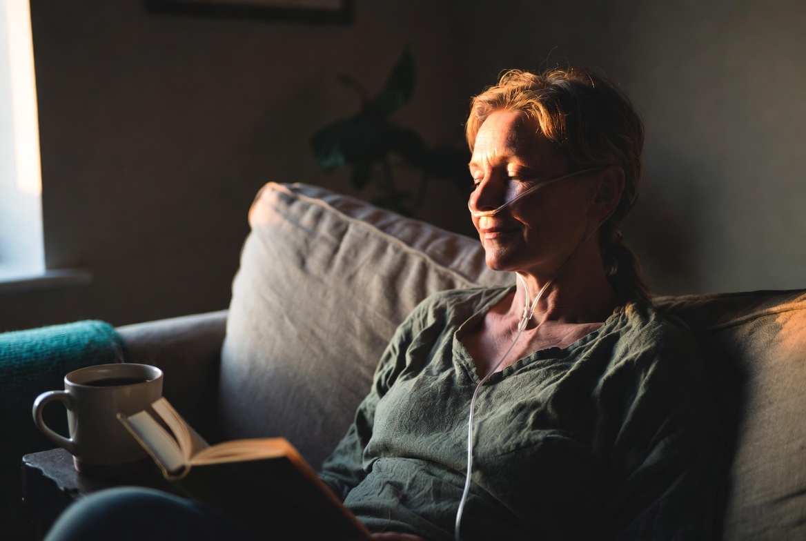 A woman reading quietly at home during a hydrogen therapy session